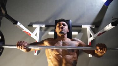 Kas yığını Afrikalı bir adam spor kulübünde halterle ağırlık çalışması yapıyor. Genç Afro Amerikalı sporcu modern spor salonunda halter egzersizleri yapıyor. Sağlıklı ve aktif yaşam tarzı konsepti. Üst görünüm.