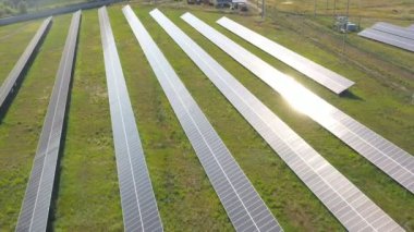Sahaya güneş panelleri yerleştirildi. Yenilenebilir yeşil enerji üreten güneş enerjisi istasyonunun hava görüntüsü. Güneş panelinin yüzeyine yansıyor. Temiz ekolojik enerji üretimi. Yakın çekim.