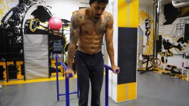 Spor salonunda paralel barlarda karın kaslarını çalıştıran güçlü bir zenci. Spor kulübünde spor yapan Afro-Amerikan sporcu. Spor salonunda spor yapan Afrikalı kaslı bir sporcu. Sağlıklı yaşam tarzı kavramı