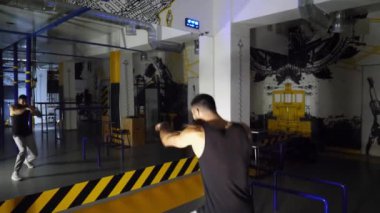 Spor kulübünde gölge boksu yapan güçlü bir sporcu. Genç kaslı sporcu modern spor salonunda havayı yumrukluyor. Spor salonunda erkek kickboksör eğitimi. Sağlıklı yaşam tarzı kavramı