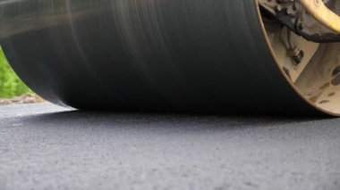 Paten yeni asfalt tabakası seriyor. Yol yapımı özel makineler. Sıkıştırıcı otoyol yapımı. Steamroller yavaşça sürüyor. Ağır makinelerle yol onarımı. Yol çalışması ve otoyol bakımı kavramı