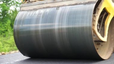 Sıkıştırıcı otoyol yapımı. Steamroller yavaşça sürüyor. Ağır makinelerle yol onarımı. Paten yeni asfalt tabakası seriyor. Yol yapımı özel makineler. Yol çalışması ve otoyol bakımı kavramı