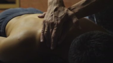 Masajcının erkek kolları kuaförde sırt masajı yapıyor. Profesyonel masör. Salondaki kaslı sporcunun omzuna masaj yapıyor. Sağlıklı yaşam tarzı kavramı. Yavaşça kapat..