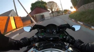 Country Street 'te motosiklet kullanan motosikletlinin bakış açısı. Gün batımında kırsal yolda motosiklet süren bir sürücünün bakış açısı. Yaz seyahati boyunca motosikletiyle yarışan bir adam. POV.