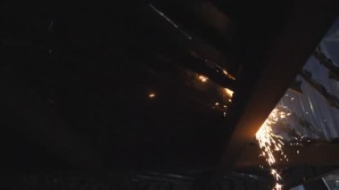 Birçok parlak kıvılcım plazma kesimi sırasında sıcak metalden uçar. Lazer kesici çalışıyor. Endüstriyel metal üretimi. Çelikten bir eser üretmek. Atölyede detayları anlatıyorum. Yavaş çekim.
