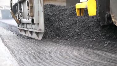 Kırsal alanda yol yapan özel makineler. Sıkıştırıcı otoyol yapımı. Ağır makineler yolu onarıyor. Yeni asfalt tabakasını yavaşça döşeyen bir paten. Yol çalışması süreci. Yol onarımı.