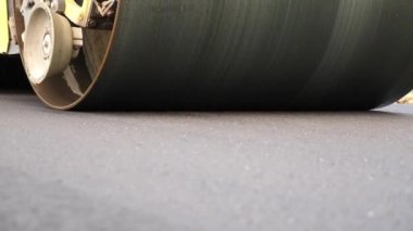 Sıkıştırıcı otoyol yapımı. Steamroller yavaşça sürüyor. Ağır makinelerle yol onarımı. Paten yeni asfalt tabakası seriyor. Yol yapımı özel makineler. Yol çalışması ve otoyol bakımı kavramı