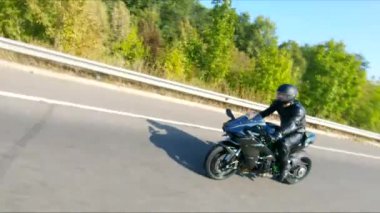 Yaz günü otoyolda hızlı giden bir adamın havadan çekilmiş fotoğrafı. Motosikletli, kır yolunda motosikletiyle yarışıyor. Yolculuk sırasında bisiklet süren bir adam. Özgürlük ve macera kavramı.