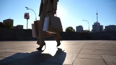Modaya uygun bir kadın, şehir caddesinde kağıt paketler taşıyor. Genç bayan müşteriler alış veriş sonrası alışveriş torbalarını meydanda tutarlar. Satış ve indirim zamanlarında boş vakit kavramı. Yavaş çekim
