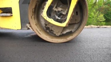 Sıkıştırıcı otoyol yapımı. Steamroller yavaşça sürüyor. Ağır makinelerle yol onarımı. Paten yeni asfalt tabakası seriyor. Yol yapımı özel makineler. Yol çalışması ve otoyol bakımı kavramı