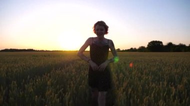 Kısa siyah elbiseli neşeli punk kızı buğday çayırlarında dolaşırken aylaklık ediyor. Dövmeli mutlu bayan hippi gün batımında yeşil arpa tarlasından geçiyor. Özgürlük kavramı.