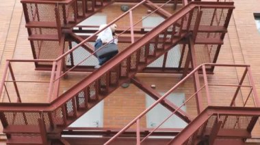 İş adamı bir iş merkezinin merdivenlerinden çıkıyor. Resmi giyinmiş, evrak çantalı, merdivenlerde yürüyen kendine güvenen bir adam. İşçi ofiste işe gidip geliyor. Başarılı kariyer kavramı