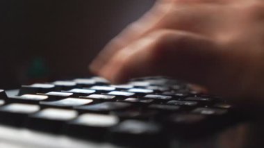 Bilgisayar klavyesinde yazı yazan erkek işadamlarının parmaklarını kapat. Tanımlanamayan iş adamı bilgisayar kullanarak yeni bir proje üzerinde çalışıyor. Verimli bir gece çalışması. Arka plan bulanık. Yavaş çekim Ayrıntılı görünüm.