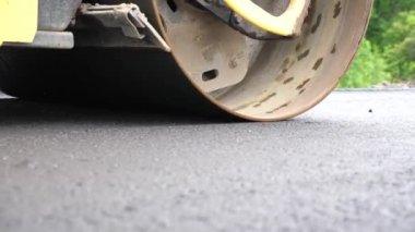 Sıkıştırıcı otoyol yapımı. Steamroller yavaşça sürüyor. Ağır makinelerle yol onarımı. Paten yeni asfalt tabakası seriyor. Yol yapımı özel makineler. Yol çalışması ve otoyol bakımı kavramı