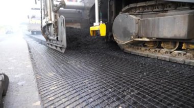 Kırsal alanda yol yapan özel makineler. Sıkıştırıcı otoyol yapımı. Ağır makineler yolu onarıyor. Yeni asfalt tabakasını yavaşça döşeyen bir paten. Yol çalışması süreci. Yol onarımı.
