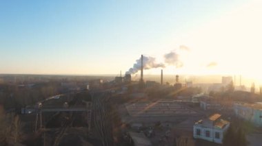 Endüstri bölgesinin hava görüntüleri borulardan atmosfere duman yayıyor. İHA fabrikanın üzerinde uçuyor ya da bitki zehirli buharı arka planda güneş ışığıyla havaya yayıyor. Çevre kirliliği sorunu.