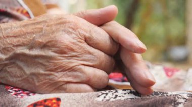 Dışarıda dinlenirken yaşlı büyükannenin ağrılı kolları. Yaşlı bir kadının kırışık elleri dışarıda. Yan Görünümü Kapat.