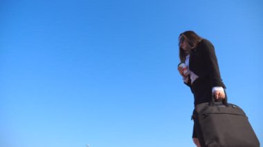 Arka planda güzel bir manzarayla şehir caddesinde yürüyen genç bir iş kadını. Kadın işe gidiyor. Kendine güveni tam bir kız ofise geliyor. Alt taraf görünümü Yavaş çekim Kapat.