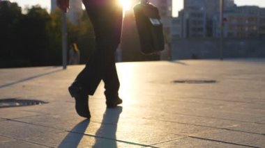 Şehirde günbatımı zaman sokak yürüyüş evrak çantası ile işadamı metrelik. Çalışmaya commuting bir iş adamı. Kendine güvenen adam büroya yolda olmak. İşçi açık olacak. Arka geri görüntülemek kapat.