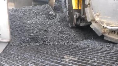 Yeni asfalt tabakasını yavaşça döşeyen bir paten. Kırsal alanda yol yapan özel makineler. Sıkıştırıcı otoyol yapımı. Ağır makineler yolu onarıyor. Yol çalışması süreci. Yol onarımı.