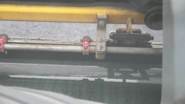 Manzara, yeni asfalt tabakasını döşeyen suyla soğutulur. Sıkıştırıcı otoyol yapımı. Tekerlekli sandalye. Ağır makinelerle yol onarımı. Yol yapımı özel makineler.