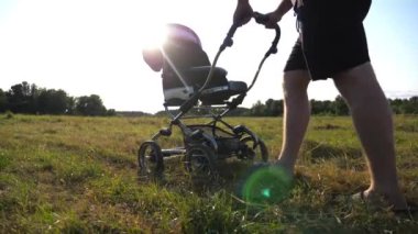 Babasının yaz günü oğluyla bebek arabasında çayırda yürürken çekilmiş bir resmi. Babam gün batımında bebek arabasıyla tarlaya gidiyor. Babası ve küçük bebeği birlikte vakit geçiriyorlar. Yavaş çekim.