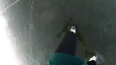Nehrin buz yüzeyinde kayan artistik patencilerin kadın ayakları. Genç sporcunun bacakları kış günü donmuş gölde paten kayıyor. Soğuk kış havasında aktif boş vakti olan bir kız. POV Yavaş çekim.