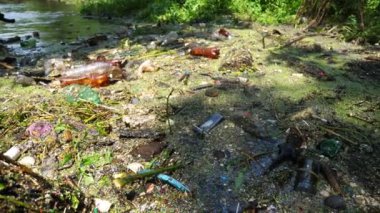 Pek çok çöp doğadaki açık ve serbestçe ulaşılabilir yerlere atılır. Kirli nehir birçok plastik şişeyle kirlidir. Küresel çevre kirliliği sorunu. Ekolojik felaket kavramı.