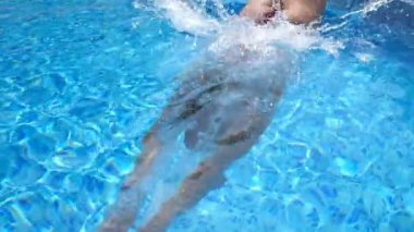 Tanımlanamayan bir kadın havuza atlayıp kristal berrak su sıçratıyor. Otelin havzasında mayo giymiş genç bir kız suyun altında yüzüyor. Bayan yaz tatilinde dinleniyor. Yavaş çekim. Yakın çekim..