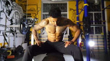 Genç Afro Amerikalı sporcu spor kulübünde halterle ağırlık çalışıyor. Kaslı sporcu Afrikalı adam modern spor salonunda halter egzersizi yapıyor. Sağlıklı ve aktif yaşam tarzı kavramı.