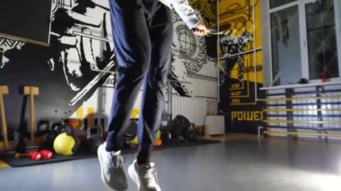 Genç Afro Amerikalı sporcu modern spor salonunda ip atlayıp atlıyor. Sporcu zenci adam spor salonunda kardiyo yapıyor. Spor giyim sektöründe spor salonunda spor yapan Afrikalı bir adam. Yavaş çekim.