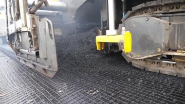 Kırsal alanda yol yapan özel makineler. Sıkıştırıcı otoyol yapımı. Ağır makineler yolu onarıyor. Yeni asfalt tabakasını yavaşça döşeyen bir paten. Yol çalışması süreci. Yol onarımı.