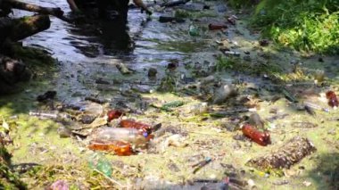 Kauçuk giysiler içinde tanınmayan erkek çevreciler kirli gölde enkaz topluyorlar. Koruyucu eldivenlerle pis nehri temizleyen gönüllüler. Çevre kirliliği koruması kavramı. Yavaş çekim