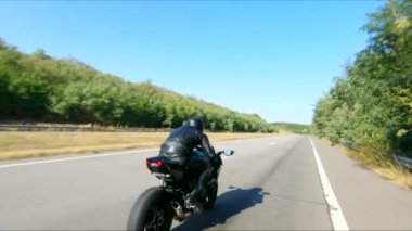 Yaz günü otoyolda hızlı giden bir adamın havadan çekilmiş fotoğrafı. Motosikletli, kır yolunda motosikletiyle yarışıyor. Yolculuk sırasında bisiklet süren bir adam. Özgürlük ve macera kavramı.
