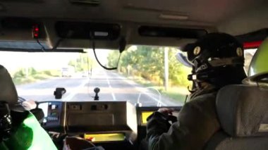 Profesyonel itfaiyeciler tam teçhizatlı itfaiye arabasıyla acil bir duruma gidiyorlar. Üniformalı erkek itfaiyeciler büyük bir kamyonla yangın yerine gidiyorlar. Hayat kurtarmak ve kahramanlık mesleği kavramı..