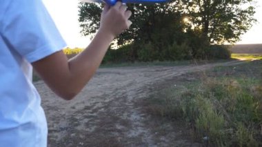 Sevimli küçük çocuk kır yolunda koşarken oyuncak uçak tutuyor. Yaz günü uçakla koşan mutlu küçük kız. Tasasız çocuk doğayla eğleniyor. Çocukluk hayali konsepti. Arka görünüm.