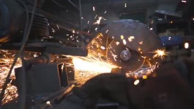 Endüstriyel imalatta çelik testeresi. Birçok parlak kıvılcım sıcak metalden uçar. Garajdaki kesim makinesini gördüm. Metal öğüten profesyonel işçilerin elleri. Yavaş çekim. Yakın çekim..
