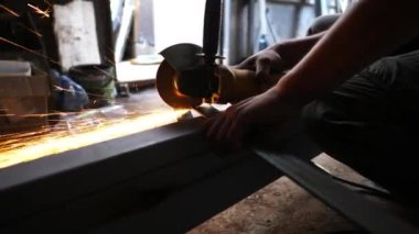 Genç tamircinin erkek elleri, atölyede elektrikli çarkla demir keser. Garajda testereyle metal testeresi kesen profesyonel bir zanaatkarın kolları. Yavaşça kapat..