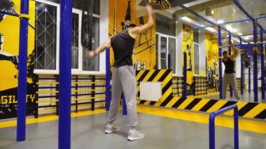 Spor salonunda egzersiz yapmadan önce ellerini esneten kaslı bir sporcu. Genç güçlü sporcu modern spor salonunda sıkı çalışmadan önce ısınıyor. Sağlıklı ve aktif yaşam tarzı kavramı. Yavaş çekim.
