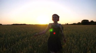 Kısa siyah elbiseli neşeli punk kızı buğday çayırlarında dolaşırken aylaklık ediyor. Dövmeli mutlu bayan hippi gün batımında yeşil arpa tarlasından geçiyor. Özgürlük kavramı.