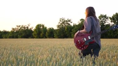 Uzun saçlı, elektro gitarı elinde tutan ve buğday tarlasında yürüyen genç bir hippi. Müzik enstrümanlı hippi adam yeşil arpa çayırlarında dolaşıyor ve gün batımında doğanın tadını çıkarıyor..