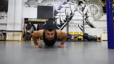 Modern spor salonunda farklı türde şınav çeken güçlü bir sporcu. Genç sporcu spor kulübünde yoğun idman yapıyor. Spor salonunda spor yapan kaslı bir sporcu. Sağlıklı yaşam tarzı.