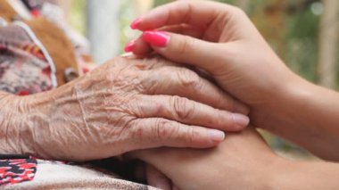 Eski buruşuk ve genç erkek ve rahatlatıcı ve açık diğer her okşayarak eller. Torunu ve birlikte vakit büyükanne. Bakım ve kavram sevgi dolu. Yan görünümü ağır çekim kapatın.