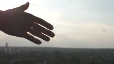 Şehir planında tanınmayan iki adamın dostane tokalaşması. Erkeklerin el sıkışarak selamlaşması. Dışarıda sıkı tokalaşan iki iyi arkadaş. Takım çalışması ve arkadaşlık. Yavaş çekim.