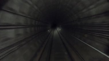 Metro treni karanlık tünelde hızla ilerliyor. Hızlı yeraltı treni tünelde ilerliyor. Şehir metrosu yerin altında. Demiryolu kulübesinden bakış açısı. İnsan taşımacılığı kavramı. Zaman aşımı.