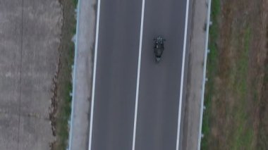 Motosikletli birinin kır yolunda motosikletiyle yarışması. Yolculuk sırasında bisiklet süren bir adam. Havadan bakıldığında, kırsal kesimde motosiklet kullanan bir motosikletli. Özgürlük ve macera kavramı.