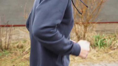 Yağmurlu bir günde kır yolunda koşan atletik bir sporcu. Genç sporcu kırsal alanda koşuyor. Açık havada kardiyo antrenmanı yapan güçlü bir atlet. Sağlıklı aktif yaşam tarzı kavramı. Kapat..