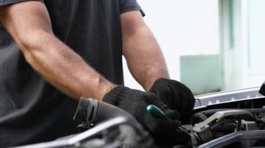 Profesyonel tamirci kolları iş yerindeki oto tamircisinin klimasını tamir ediyor. Aracın kaputu altında çalışan tamircinin erkek elleri. Bakım ve otomobil kontrolü kavramı. Yavaş çekim.