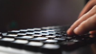 Bilgisayar klavyesinde yazı yazan erkek işadamlarının parmaklarını kapat. Tanımlanamayan iş adamı bilgisayar kullanarak yeni bir proje üzerinde çalışıyor. Verimli bir gece çalışması. Arka plan bulanık. Yavaş çekim Ayrıntılı görünüm.