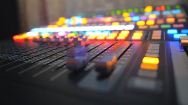 Dj uzaktan kumandasının hareket eden düğmeleri düşük görünümü. Kayıt stüdyosunda çalışma süreci. Yükseltici ve ses dengesi. Gece kulübündeki partide bir müzisyen. Arka planda parlak anahtarlar. Yavaş çekim.